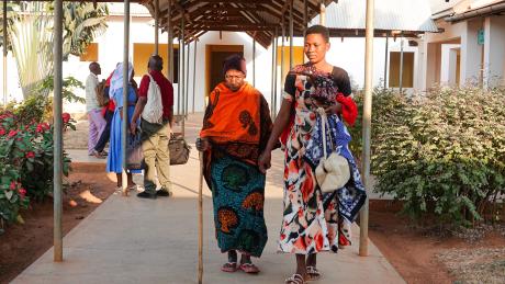 Rozalia Masanja supported by her granddaughter, Cecilia, to come for surgery