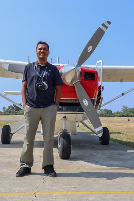 A man stands in front of a small plane