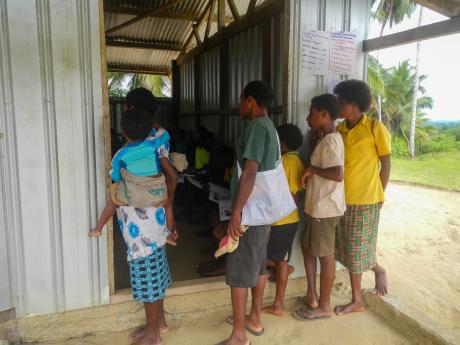 People stand outside a full church listening