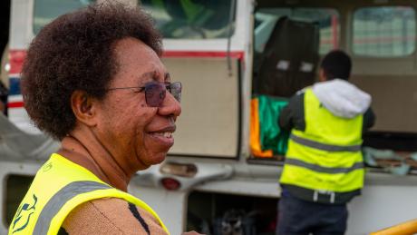Lynn Babah in front of MAF aircraft smiling