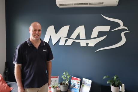 Man standing in front of blue wall inside training centre