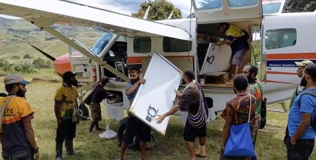 Offloading the vaccine fridges and solar panels at Ambi