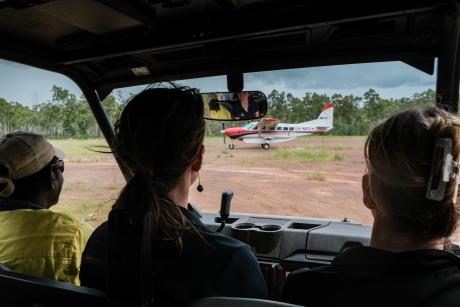 People in offroad buggy approaching on red dirt airstrip